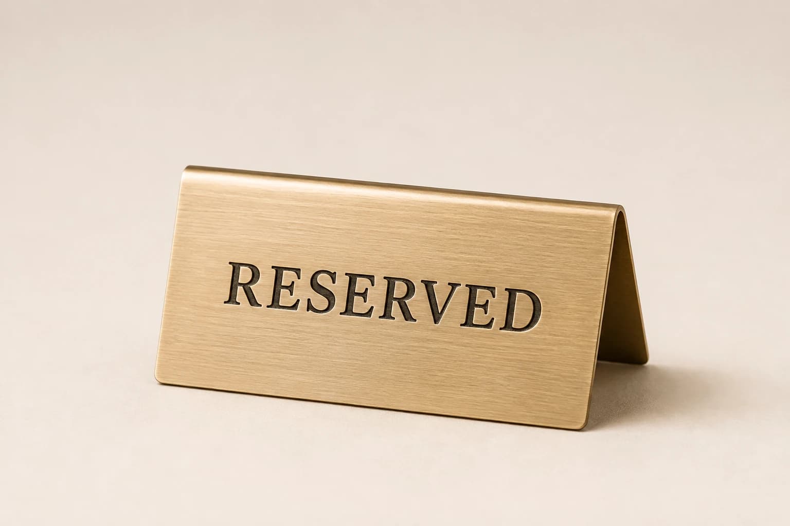 Brushed champagne metal reserved sign with a folded tent profile.