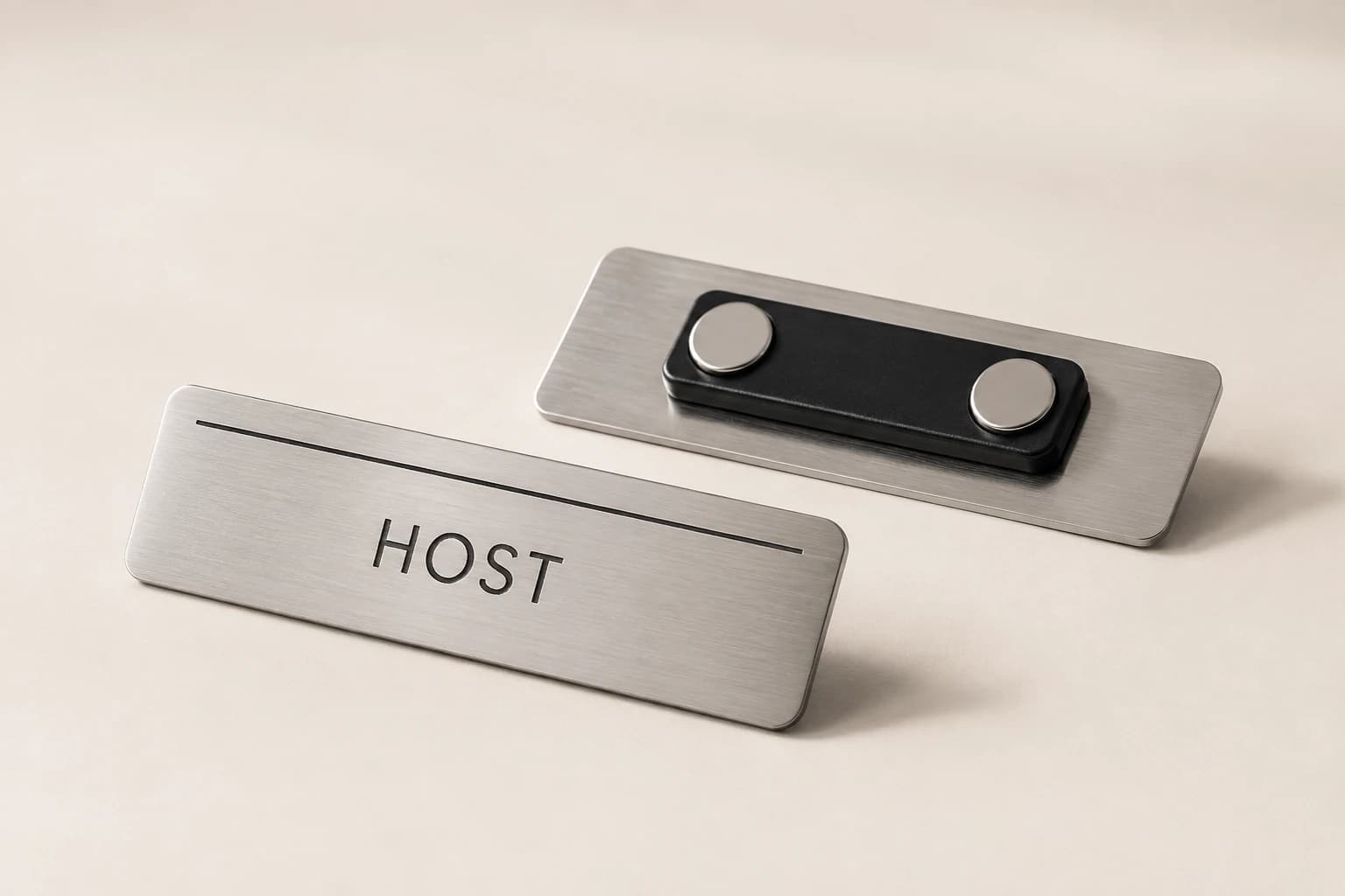 Silver restaurant staff badge shown from the front and magnetic back.